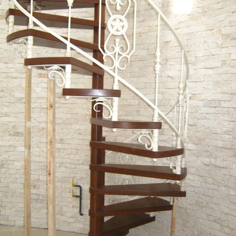 Винтовая кованая лестница с деревянными забежными ступенями